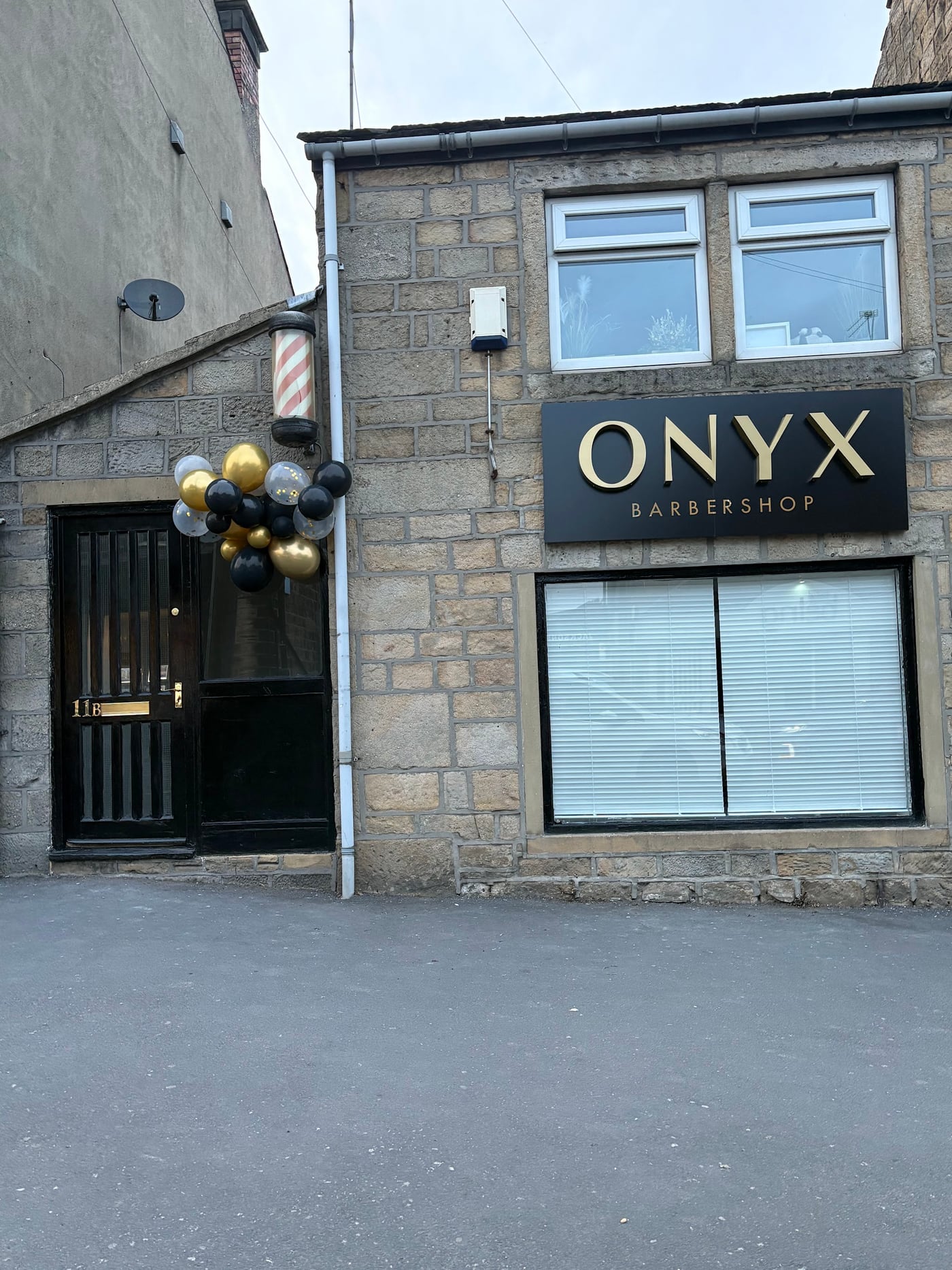Onyx Barbershop's stone shopfront on Station Road with its black and gold sign